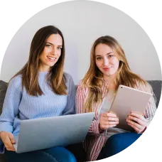 Mulheres sentadas com laptop e tablet trabalhando juntas